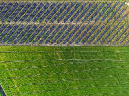 Foto de Impresionante vista aérea de paneles solares dispuestos en un campo durante la puesta del sol, capturando la belleza de la innovación de energía verde y la ecología sostenible. - Imagen libre de derechos