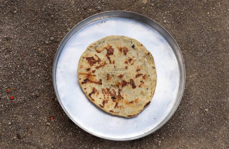 Téléchargez les photos : Gujarati traditionnel sorgho ki roti ou pain plat au mil perlé. déjeuner de fermier ou des articles communs consommés dans le déjeuner qui sont bajre ki roti. Jowar Roti ou pain indien, consommé par la classe ouvrière en milieu rural - en image libre de droit
