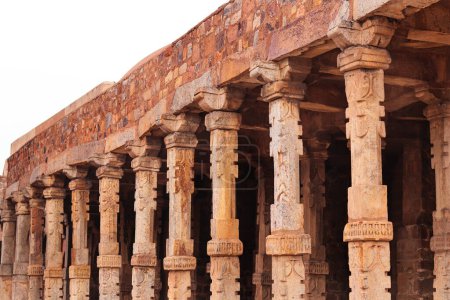 Antike Säulen mit einem unendlichen Betrachter in der Nähe der Qutub Minar Säulen mit Steinschnitzereien im Hof der Quwwat-Ul-Islam Moschee, Qutub Minar Komplex. Es ist UNESCO-Weltkulturerbe in Neu Delhi Indien