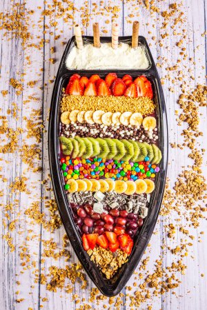Acai frozen with banana, kiwi fruit, granola and candies for share. A boat for share.