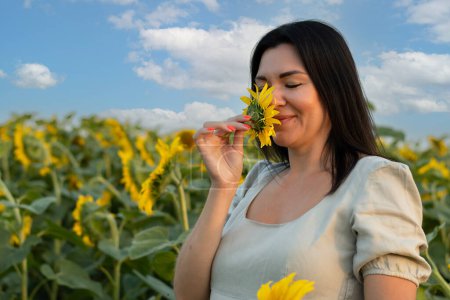 Téléchargez les photos : Le symbole de l'Ukraine. Une belle fille se tient joyeusement dans un champ avec des tournesols jaunes et inhale le parfum des fleurs. Gros plan. - en image libre de droit