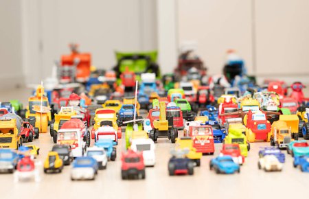 Photo for Toy cars, motorcycles, tractors, buses, pickups, many colorful small and large cars are arranged for play on the floor in the childrens room. Childhood concept. soft focus. - Royalty Free Image