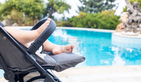 Téléchargez les photos : Bébé heureux dans sa poussette en vacances en plein air - en image libre de droit