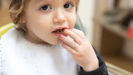 Téléchargez les photos : Bébé de deux ans mangeant des pâtes à la sauce tomate - en image libre de droit