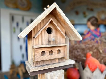Téléchargez les photos : Une mangeoire à oiseaux en bois près de la maison. Concentration sélective de la part de l'alimentateur. Photo de haute qualité - en image libre de droit