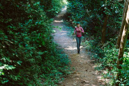 Foto de Asiática joven fitness mujer running en bosque trail - Imagen libre de derechos