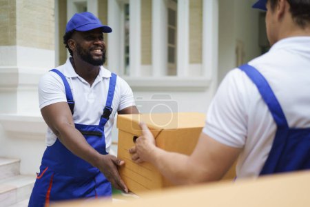 Photo for Couple courier house mover handover cardboard box in to the truck. - Royalty Free Image