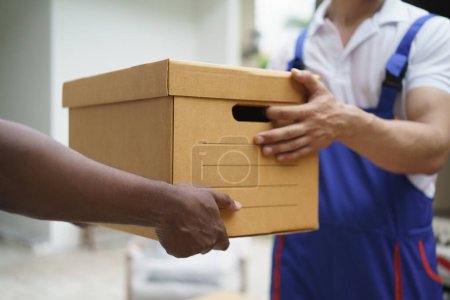 Photo for Close up of courier man handover cardboard box. - Royalty Free Image