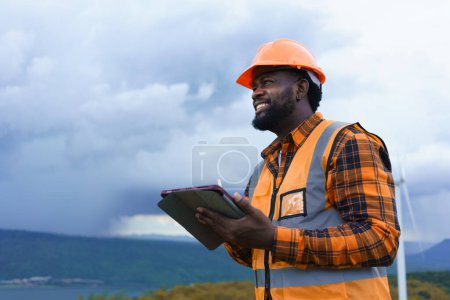Photo for Black Engineer wearing safety jacket and hardhat holding tablet while working at outdoor, Smart working lifestyle. - Royalty Free Image