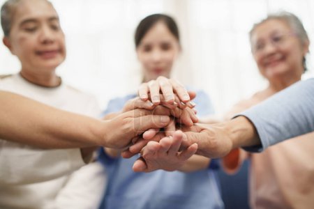 Photo for Happy Asian elderly people hands join together in the middle with young woman nursing elderly care. Selective focus on a hands. - Royalty Free Image