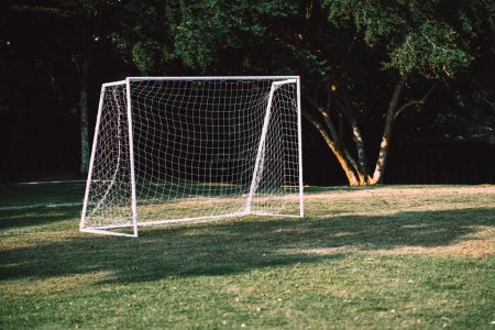 Photo for Football goal put on the grass field without people in the park. A mini net goal at playground for small groups people can have exercise activities and leisure. - Royalty Free Image