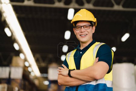 Téléchargez les photos : Portrait de l'homme asiatique superviseur d'entrepôt travail entrepôt de distribution à et la gestion des stocks et de la logistique. Inspecteur industriel travaillant en usine. - en image libre de droit