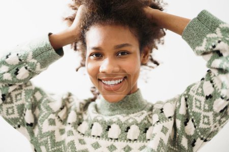 Téléchargez les photos : Gros plan Portrait de charmante femme afro-américaine avec confiance pour sourire avec de belles dents. Style de vie dame optimiste avec coiffure bouclée. - en image libre de droit