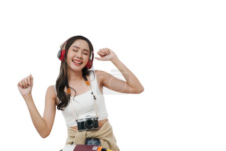 Photo for Portrait of a happy Asian young woman dancing and enjoying listening to music feeling relaxed, having a camera ready for travel, copy space, white background - Royalty Free Image