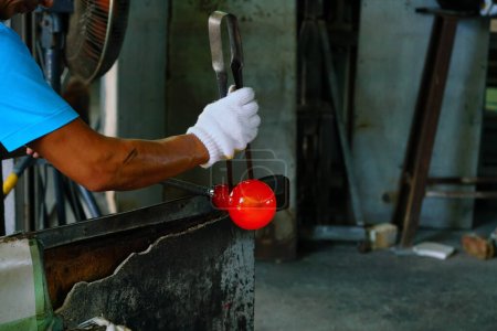 Foto de Okinawa, Japón - 25 de octubre de 2016: Unidentified Man forming a hot glass at Ryukyu Glass Village, a Tourist attraction for a glass factory in Okinawa Japón. - Imagen libre de derechos