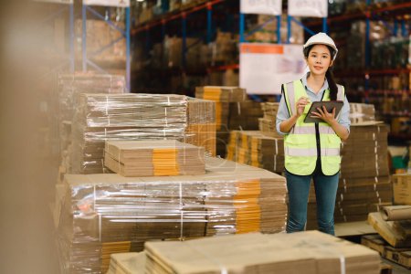 Foto de Retrato de una mujer asiática supervisora de almacén que trabaja en almacén de distribución para administrar inventario y logística. - Imagen libre de derechos