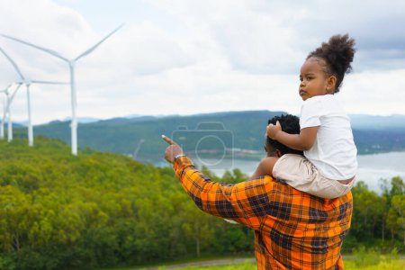 Photo for Young African American Girl and Dad Amidst Wind Energy - Royalty Free Image