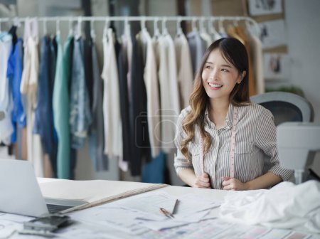 Photo for Smiling Asian Fashion Designer Crafting Trendy Clothing in her Boutique Shop. - Royalty Free Image