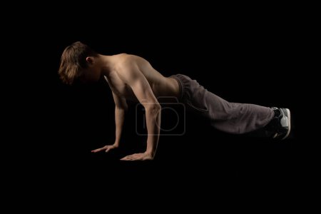 Photo for A 17 year old shirtless muscular teenage boy doing push ups - Royalty Free Image