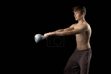 Photo for A 17 year old shirtless muscular teenage boy doing kettlebell swings - Royalty Free Image