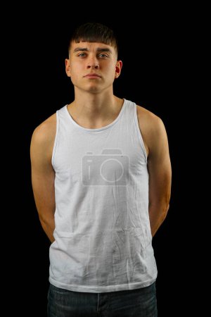 Foto de Retrato de un adolescente con un top blanco sin mangas sobre un fondo negro - Imagen libre de derechos