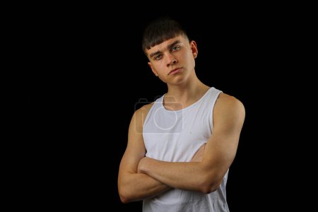 Foto de Retrato de un adolescente con un top blanco sin mangas sobre un fondo negro - Imagen libre de derechos
