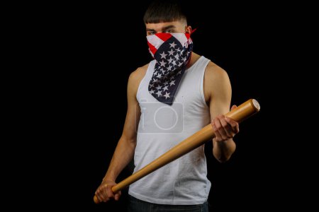 Foto de Adolescente vistiendo un chaleco blanco con una máscara de bandera americana sosteniendo un bate de béisbol - Imagen libre de derechos