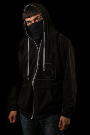 Foto de Adolescente con máscara negra y sudadera con capucha negra - Imagen libre de derechos