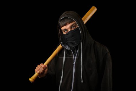 Foto de Adolescente con máscara negra, sudadera con capucha y bate de béisbol - Imagen libre de derechos