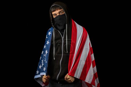 Foto de Adolescente con capucha y máscara sosteniendo una bandera americana - Imagen libre de derechos