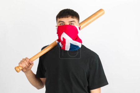 Foto de Adolescente con una máscara de Union Jack sosteniendo un bate de béisbol sobre un fondo blanco - Imagen libre de derechos