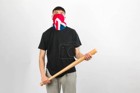Foto de Adolescente con una máscara de Union Jack sosteniendo un bate de béisbol sobre un fondo blanco - Imagen libre de derechos