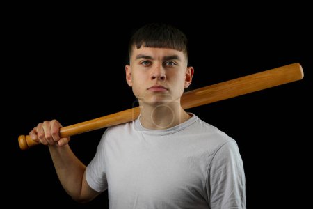 Foto de Un adolescente con un bate de béisbol sobre un fondo negro - Imagen libre de derechos