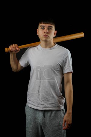 Foto de Un adolescente con un bate de béisbol sobre un fondo negro - Imagen libre de derechos