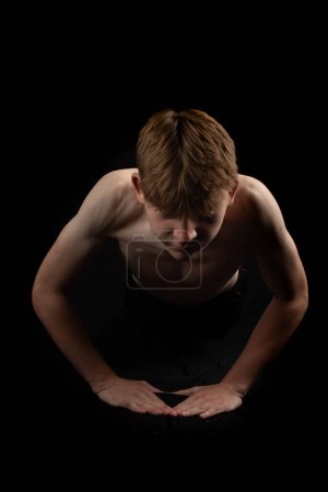 Foto de Retrato de un adolescente sin camisa deportivo haciendo flexiones de presión desde el frente - Imagen libre de derechos