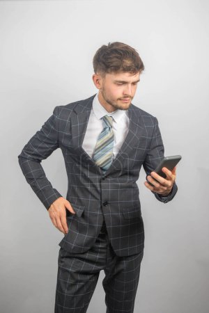 Foto de Retrato de un joven empresario en traje y corbata leyendo un mensaje en su teléfono - Imagen libre de derechos