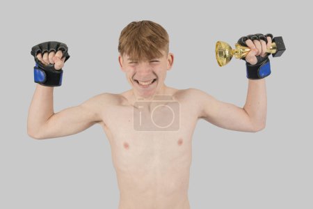 Photo for Shirtless male teenage MMA fighter with a trophy - Royalty Free Image