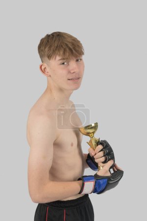 Photo for Shirtless male teenage MMA fighter with a ttrophy - Royalty Free Image
