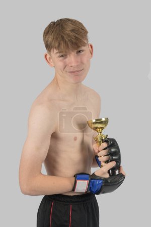 Photo for Shirtless male teenage MMA fighter with a trophy - Royalty Free Image