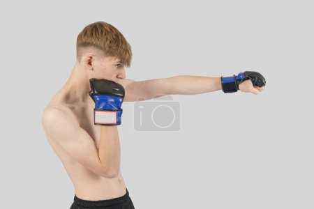 Photo for Shirtless male teenage MMA fighter punching - Royalty Free Image