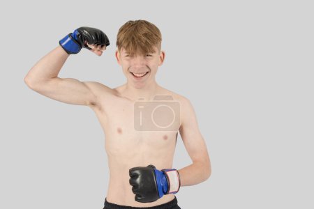Photo for Shirtless male teenage MMA fighter flexing one of his arms - Royalty Free Image