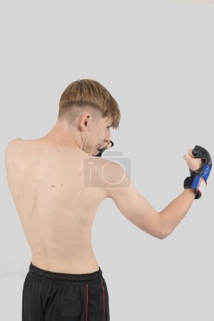 Photo for Shirtless male teenage MMA fighter doing an uppercut - Royalty Free Image
