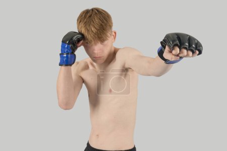 Photo for Shirtless male teenage MMA fighter punching - Royalty Free Image