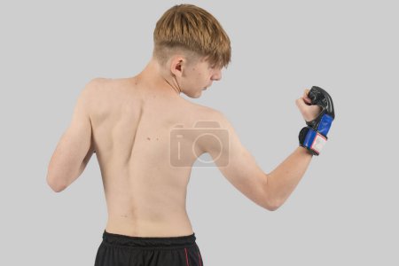 Téléchargez les photos : Torse nu adolescent MMA combattant faire un uppercut - en image libre de droit