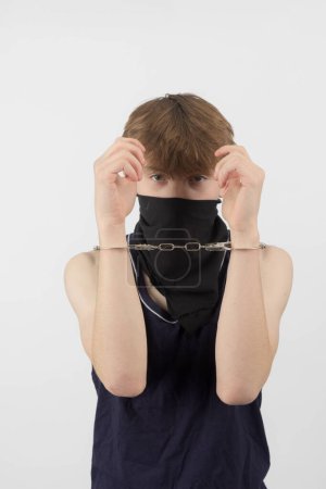 Ein maskierter Teenager in Handschellen festgenommen