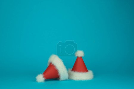 Foto de Dos Santa Clauss rojo con sombreros de plumas blancas sobre fondo verde. Tarjeta de estilo mínimo. Foto de alta calidad - Imagen libre de derechos