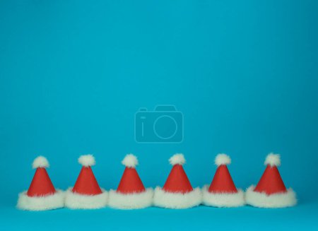 Photo for Two Santa Clauss red with white feather hats on green background. Minimal styled card. High quality photo - Royalty Free Image