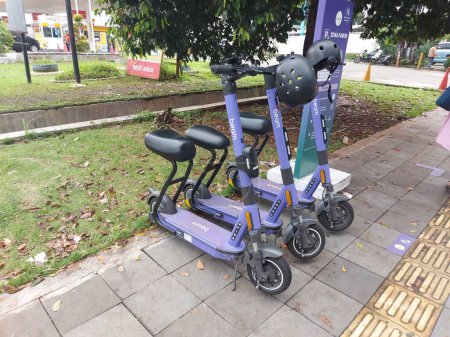 Téléchargez les photos : Bogor, indonesia-jan 1 2023 : scooter violet sur rue piétonne à louer. il s'agit d'une installation de transport public du gouvernement - en image libre de droit
