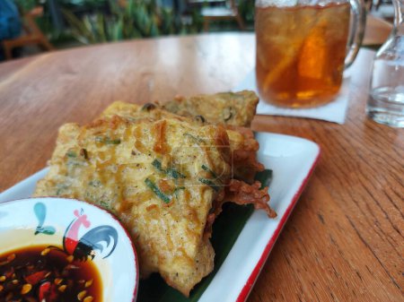 Téléchargez les photos : Tempe mendoan. It is traditional food from Indonesia. Made from fried tempeh which wrapped with flourm served with sweet soy sauce. - en image libre de droit