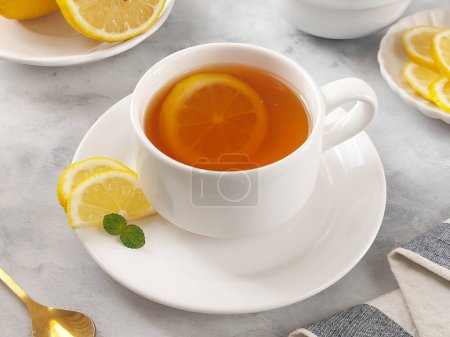 Téléchargez les photos : Une tasse de thé au citron chaud. Fond isolé en blanc - en image libre de droit